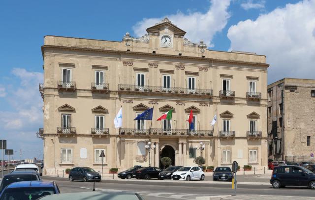 La facciata di Palazzo di Città, il Municipio di Taranto, in piazza Castello sotto un cielo azzurro